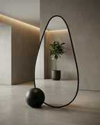 A premium asymmetrical black floor mirror with a modern irregular frame by Arris Concepts Luxury Pvt. Ltd.
