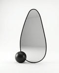 A premium asymmetrical black floor mirror with a modern irregular frame by Arris Concepts Luxury Pvt. Ltd.