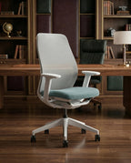 Modern desk chair with teal seat and premium ergonomic mesh office chair by Arris Concepts Luxury Pvt. Ltd.
